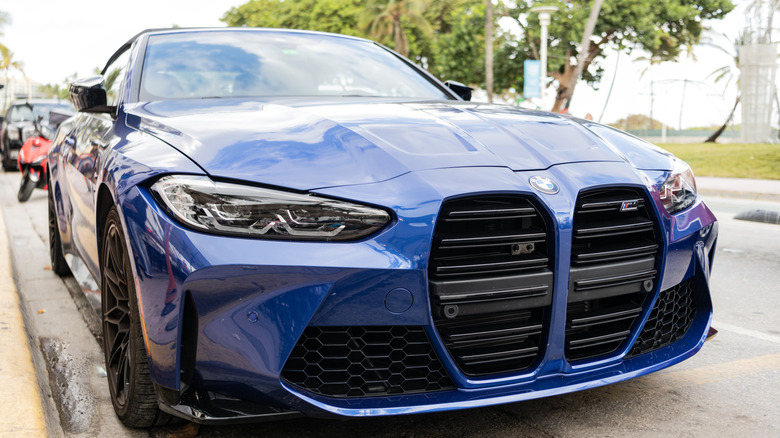 A front bumper view of a blue 2021 BMW M4