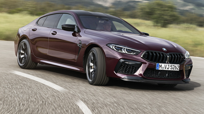 A 2021 BMW M8 Gran Coupe in purple ripping down a winding road.