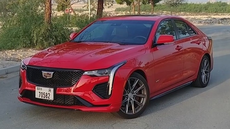 A 2021 Cadillac CT4-V parked on a paved road next to trees