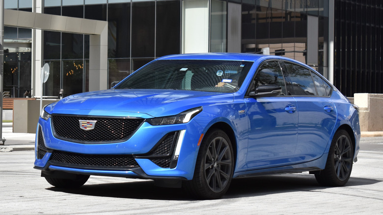 A front-left 3/4 view of a blue 2021 Cadillac CT5 Sport in the city