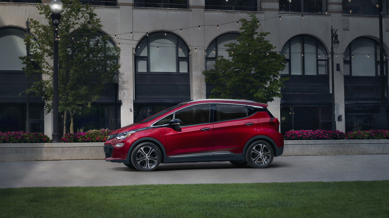 A red 2021 Chevrolet Bolt in front of a building.