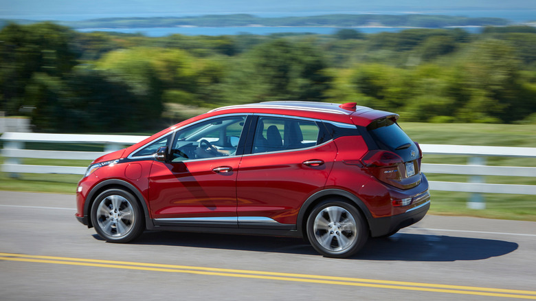 A red 2021 Chevrolet Bolt on a roadway.