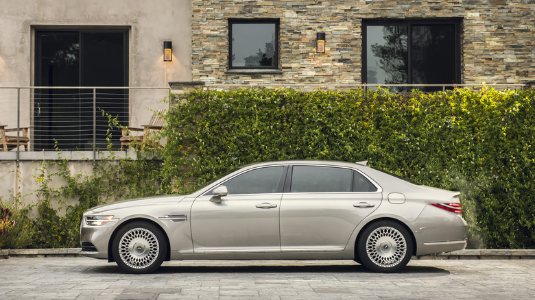 A silver 2021 Genesis G90 in front of a building.