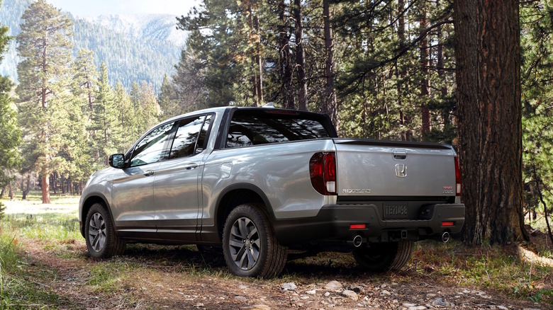 A silver 2021 Honda Ridgeline parked next to trees in the woods
