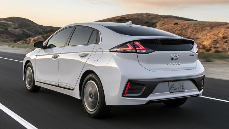 A white 2021 Hyundai Ioniq Electric in motion on a highway.