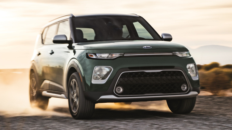 Front-right 3/4 view of a 2021 Kia Soul X-Line driving on a dirt road