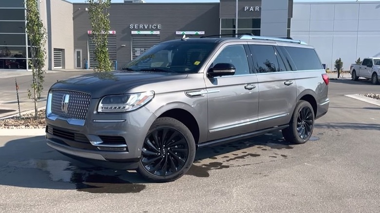 A 2021 Lincoln Navigator L parked on a paved surface in front of a Lincoln dealership building