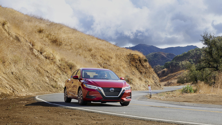 A red 2021 Nissan Sentra on a country road.