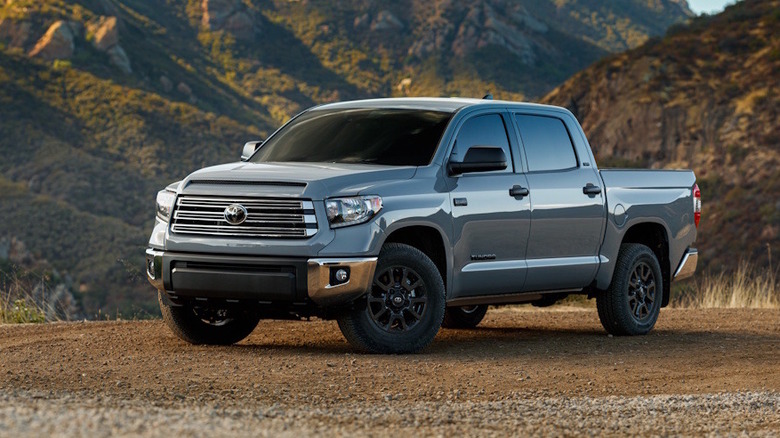 A gray 2021 Toyota in front of hilly terrain.