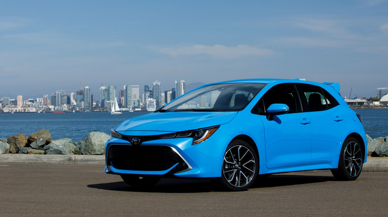 A blue 2021 Toyota Corolla Hatchback in front of a waterway.