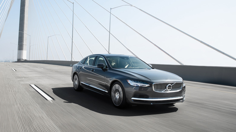 A gray 2021 Volvo S90 driving on a bridge