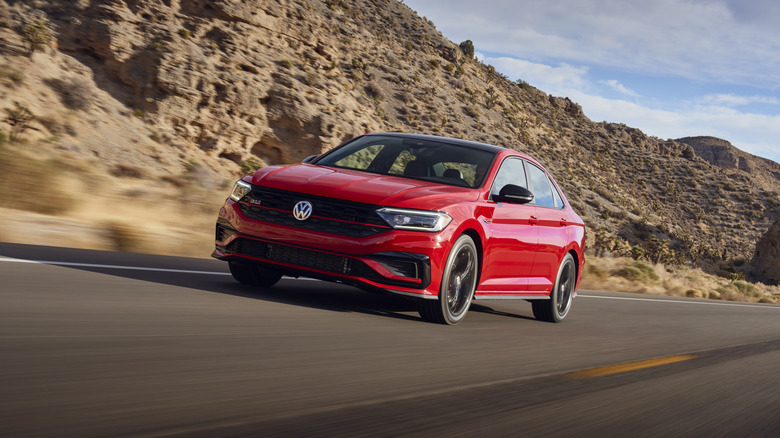 A red 2021 Volkswagen Jetta GLI on a roadway against a mountainous desert background