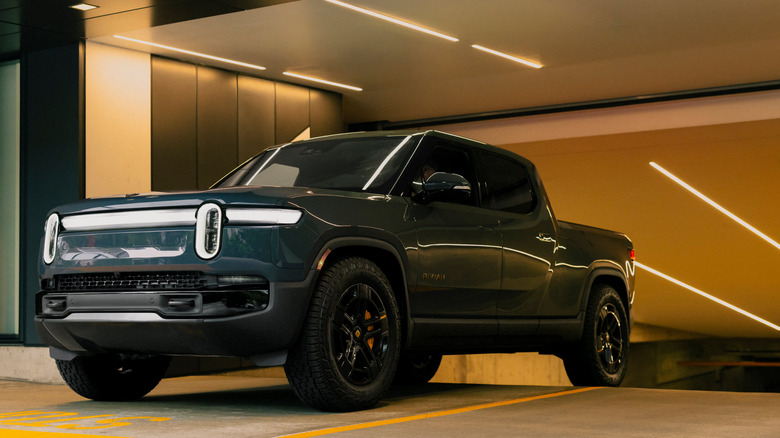 A blue Rivian R1T exiting a parking garage.