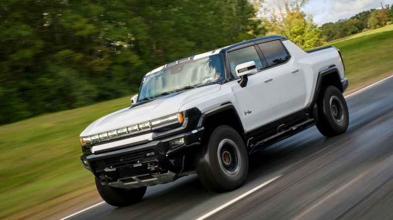 A white 2022 GMC Hummer EV pickup on a roadway.