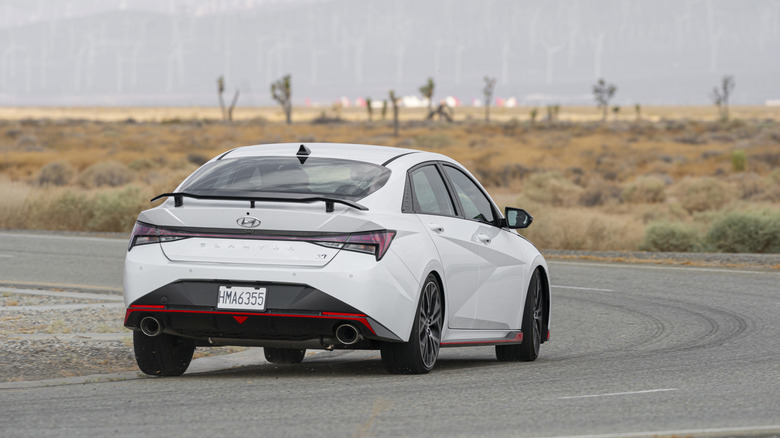 Rear 3/4 view of a white 2023 Hyundai Elantra N on track.