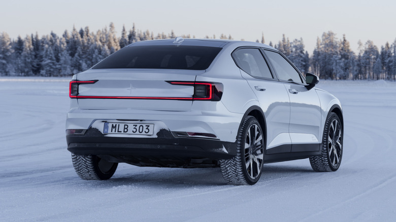 A rear three-quarter view of a white Polestar 2 parked in wintery conditions.