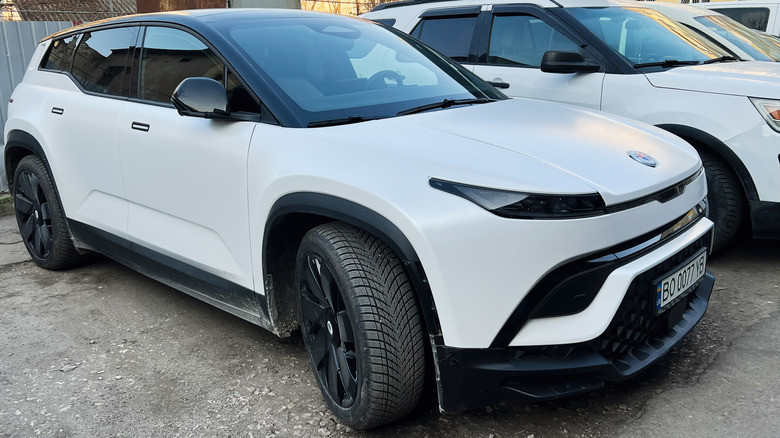 Fisker Ocean parked with its wheels turned in a gravel parking lot