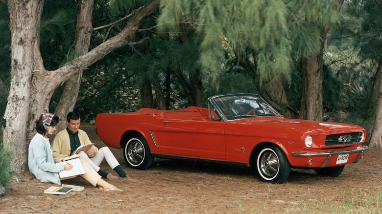 A promotional image of a red 1964 Ford Mustang Convertible