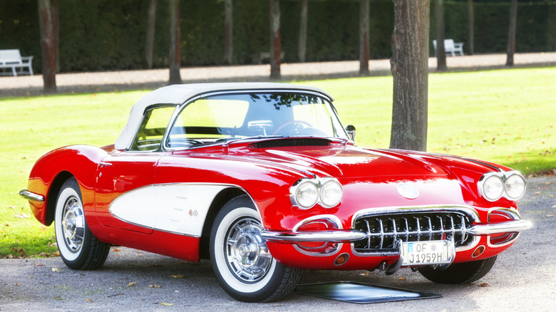 A red Chevy C1 Corvette convertible on display in an outdoor parking lot