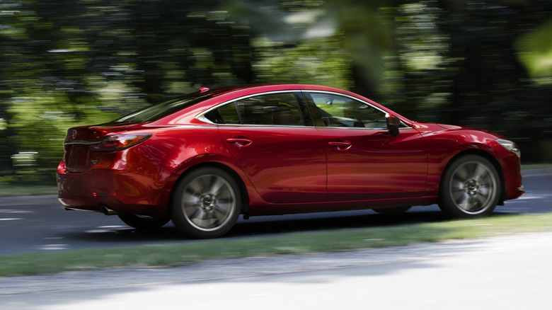A right side view of a Soul Red Crystal Metallic 2021 Mazda 6 on a backroad