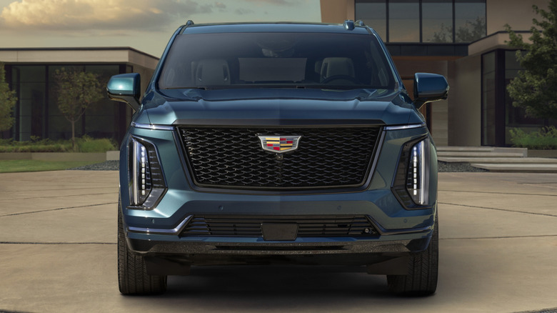 A front-end view of a big dark blue Cadillac Escalade SUV.