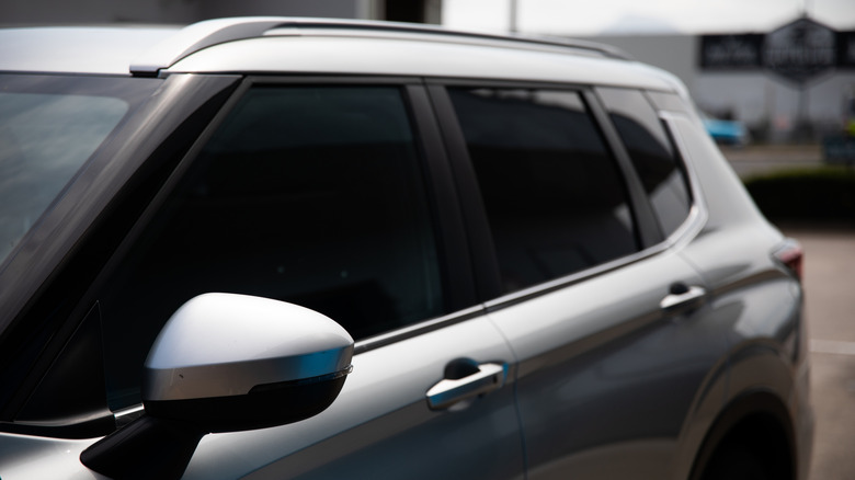 Parked silver SUV with dark tinted windows