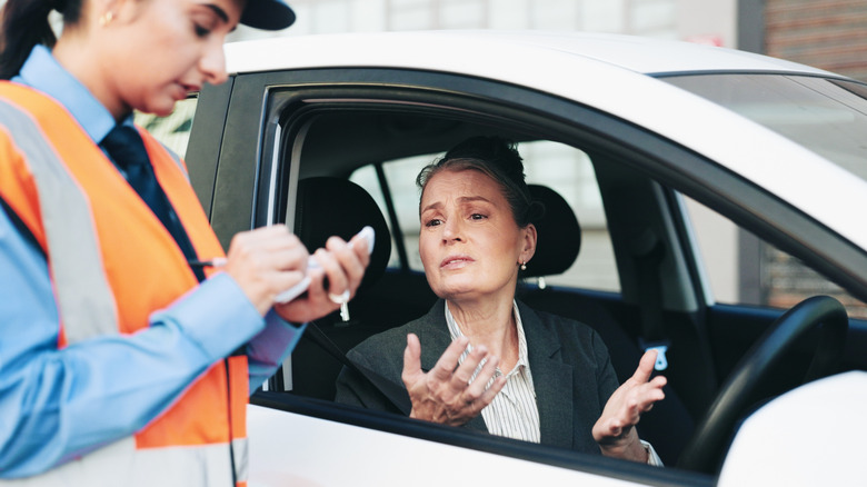 Woman receiving a traffic ticket.