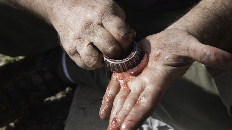 Packing grease in a wheel bearing by hand.
