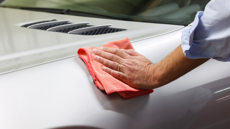 Man removing wax reside with a microfiber towel
