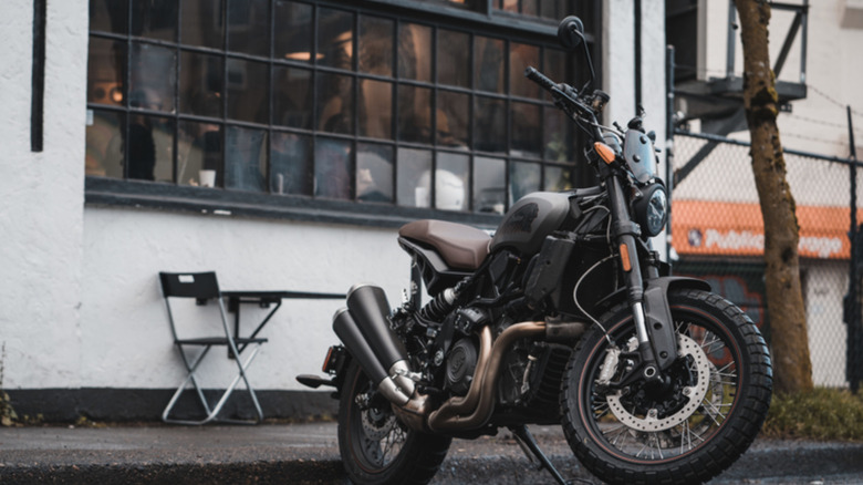 A Indian FTR1200 parked in front of a building with many windows