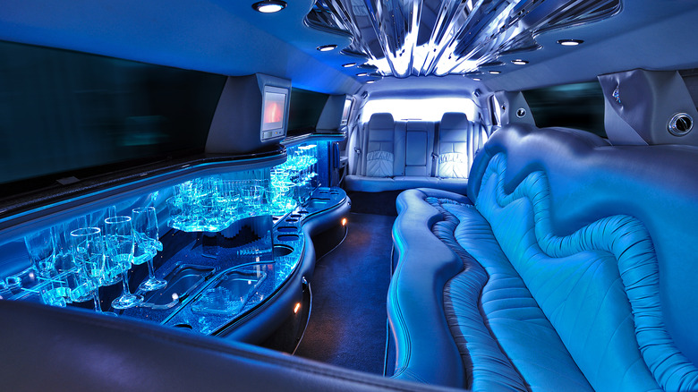 The fancy interior of a stretch limousine with plush leather and a mini bar