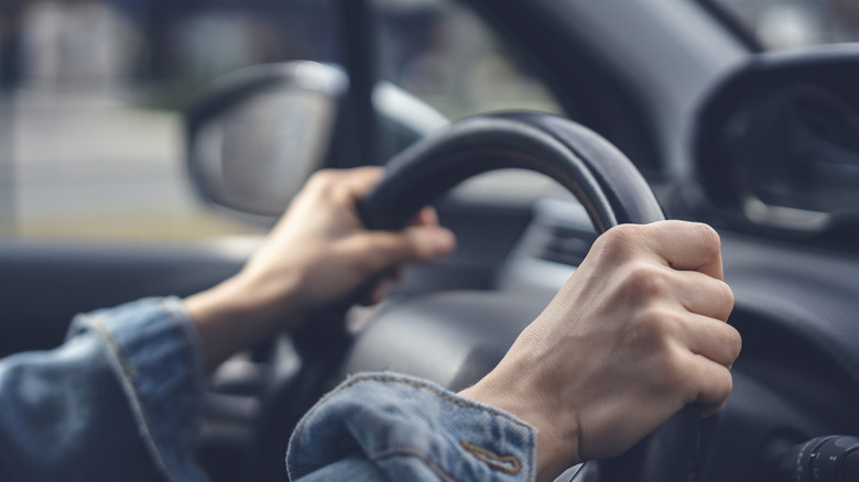 Hands gripping a steering wheel