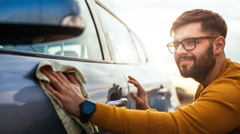 Driver polishing their car with microfiber cloth