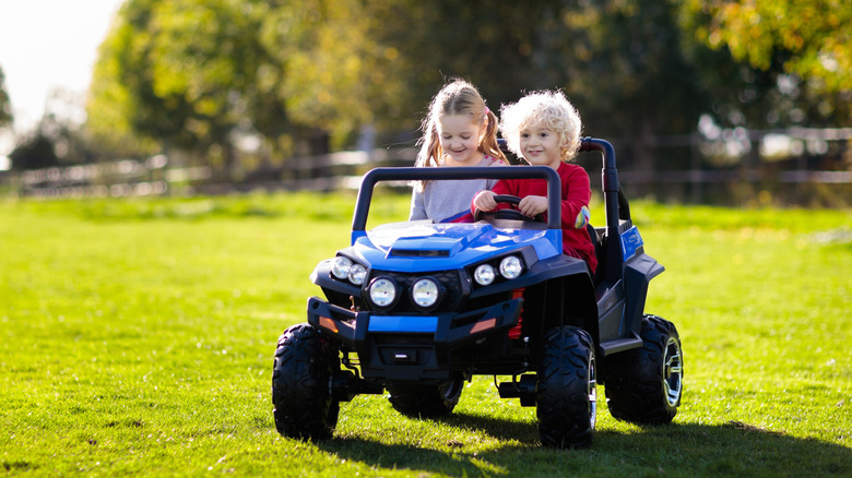 Two kids driving a Power Wheels