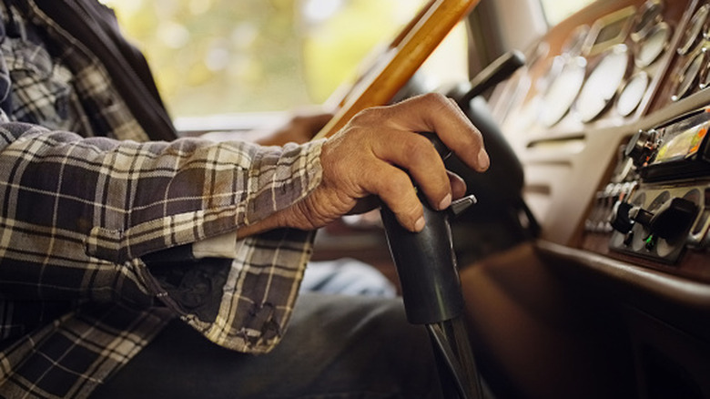 A person shifting gears inside of a car