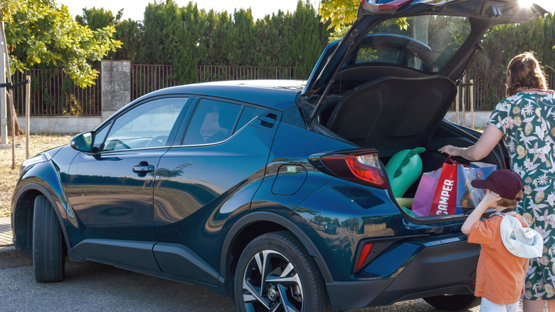 A family load groceries into their car's cargo hold