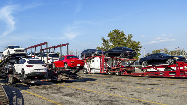 Multiple cars on transportation trailers.