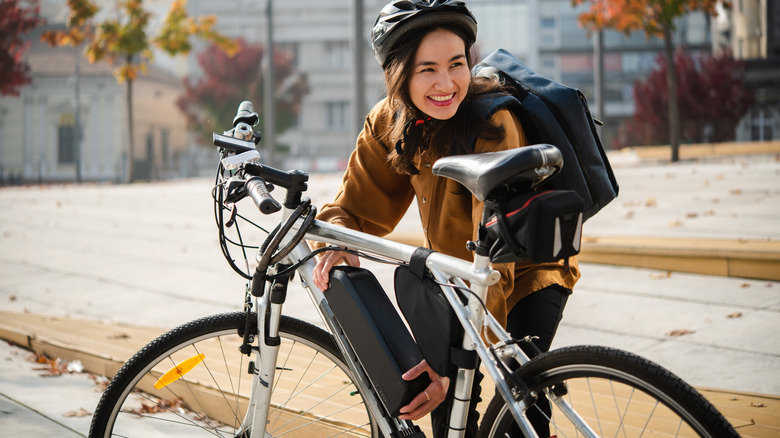 A woman installing the battery on her electric bicycle