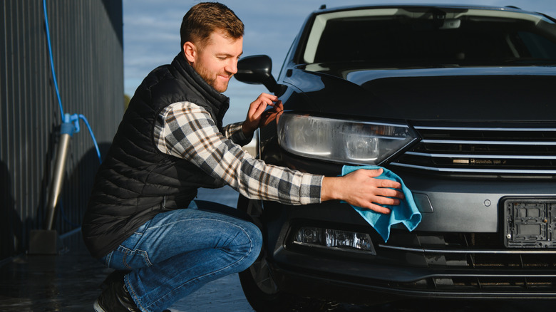 A man drying a car with a microfiber towel
