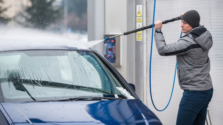 A person washing a car in cold weather