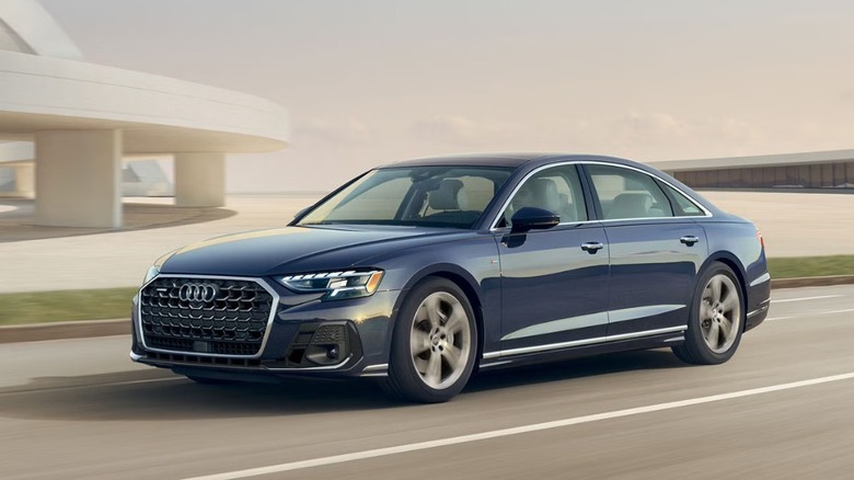 A dark blue Audi A8 sedan driving on the road.