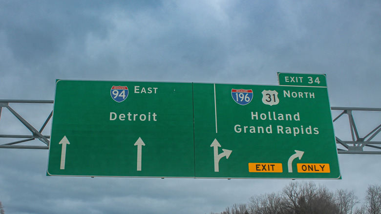 Benton Township, Michigan, USA – November 22, 2025: Interstate 94 East and Interstate 196 US 31 North directional highway signs for Detroit, Holland, and Grand Rapids under overcast winter skies