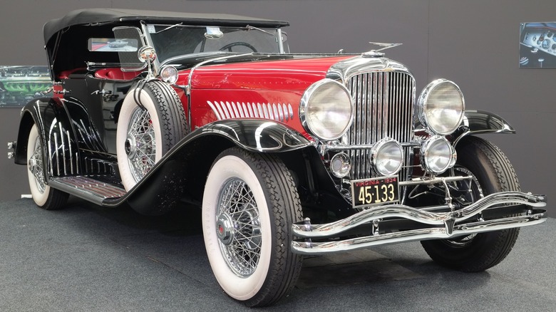 A red and black 1934 Duesenberg Model J parked at the Warbirds & Wheels museum