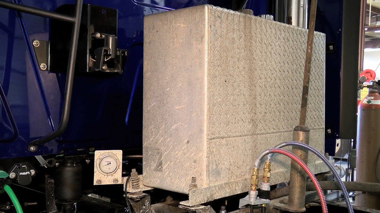 A hydraulic tank for a semi truck wet kit connected to a truck.