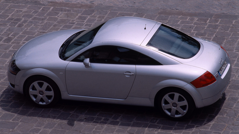 A silver gray Audi TT Coupe on a brick road