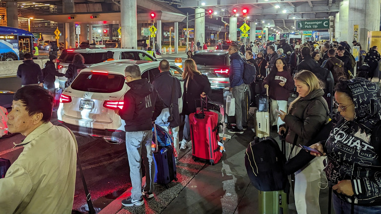Crowd of people waiting for transportation at JFK airport.