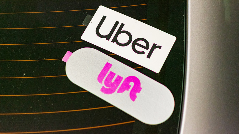 Uber and Lyft stickers on the rear window of a rideshare vehicle