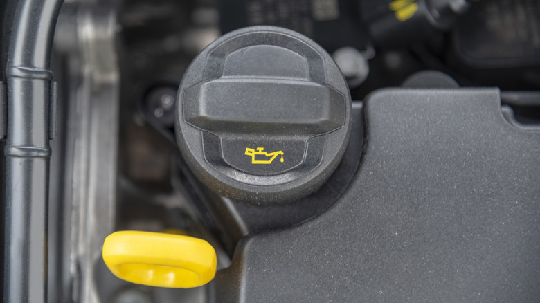 The dipstick and oil fill cap of a car engine