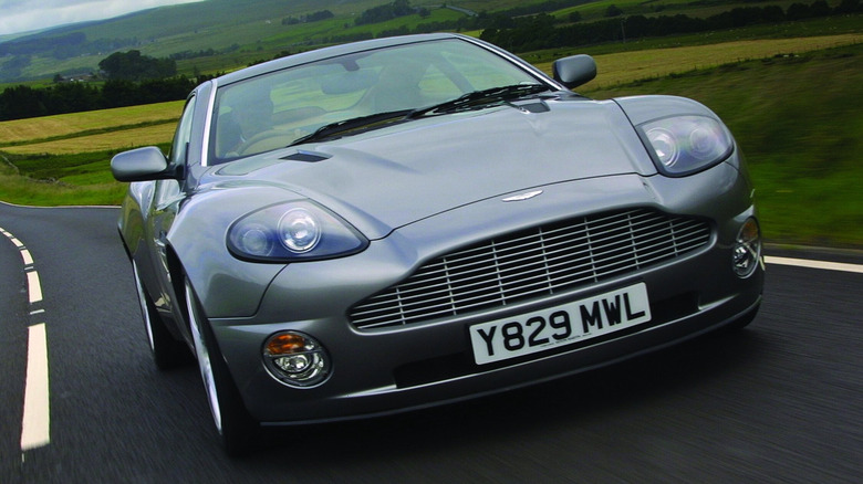 A 2001 Aston Martin Vanquish driving on a country road