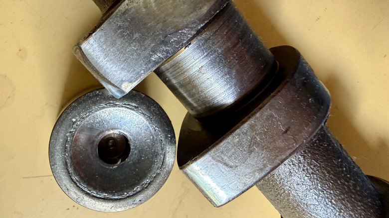 A busted valve lifter and worn camshaft lobe, thanks to the lifter freezing up.